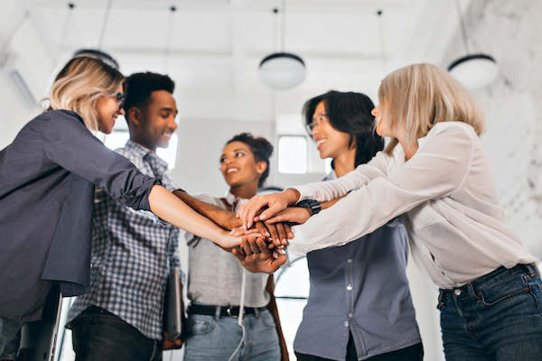 cheerful-international-students-with-happy-face-expression-going-work-together-science-project-indoor-photo-blonde-woman-trendy-blouse-holding-hands-with-coworkers (1) (1)